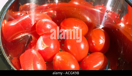 Les tomates cerise lavées à l'égouttoir en acier inoxydable Banque D'Images