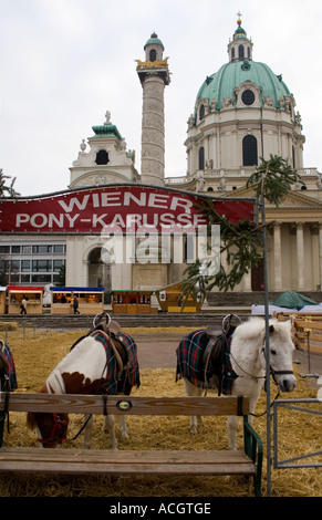 Poneys en attente de donner aux manèges de marché de Noël en face de l'église St Charles Karlskirche Banque D'Images