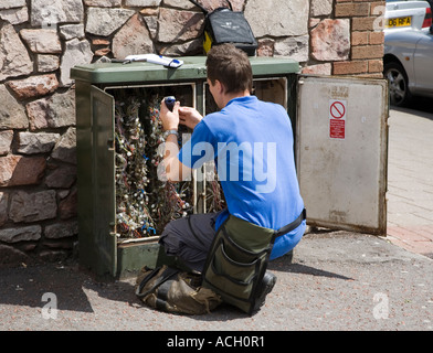 British Telecom ingénieur travaillant sur une boîte de jonction de câbles téléphoniques Wales UK Banque D'Images