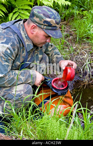 Komsomolsk Russie Juin 2007 Un feu de forêt, une patrouille de combat des incendies de forêt éteint comble une vessie d'eau d'une source Banque D'Images