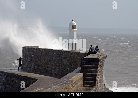 Regarder les surfeurs vagues briser contre le phare de Porthcawl, dans le sud du Pays de Galles, Royaume-Uni. Banque D'Images