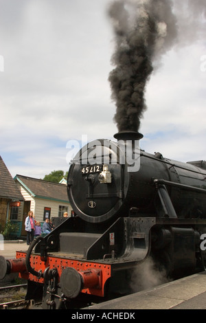 Les badauds regarder une épaisse fumée noire émaner de locomotive vapeur 45212 à Grosmont N Yorks UK gare Banque D'Images