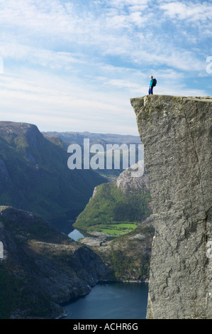 Walker debout sur Preikestolen, ou Pulpit Rock, au-dessus de Lysefjorden, Dale i Sunnfjord, Rogaland,. Banque D'Images