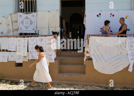 Femme à la dentelle à feuilles et nappes à vendre à un marché de rue, Trinidad, Cuba. Banque D'Images