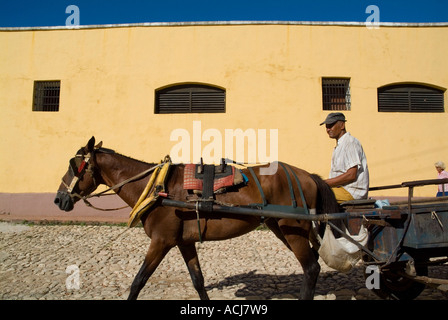 Homme monté sur son cheval et panier panier le long d'une rue pavée, Trinidad, Cuba Banque D'Images