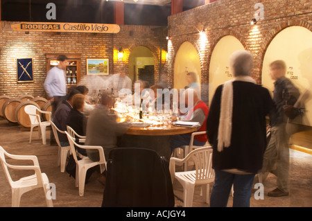 Le vigneron et œnologue et d'un groupe de dégustateurs de vin dans la cave de dégustation. Un signe sur le mur en disant Bodegas Castillo Viejo. Bodega Castillo Viejo Winery, Las Piedras, Canelones, Uruguay, Amérique du Sud Banque D'Images