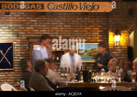 Le vigneron et œnologue et d'un groupe de dégustateurs de vin dans la cave de dégustation. Un signe sur le mur en disant Bodegas Castillo Viejo. Bodega Castillo Viejo Winery, Las Piedras, Canelones, Uruguay, Amérique du Sud Banque D'Images