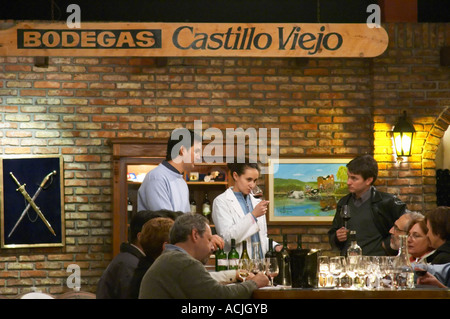 Le vigneron et œnologue et d'un groupe de dégustateurs de vin dans la cave de dégustation. Un signe sur le mur en disant Bodegas Castillo Viejo. Bodega Castillo Viejo Winery, Las Piedras, Canelones, Uruguay, Amérique du Sud Banque D'Images