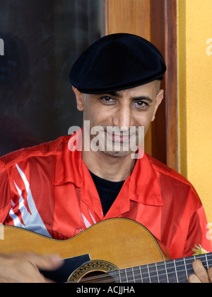 Le guitariste flamenco espagnol en chemise rouge et béret noir Banque D'Images