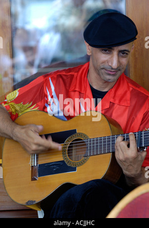 Le guitariste flamenco espagnol en chemise rouge et béret noir Banque D'Images