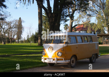 Une vieille Volkswagen partage de l'écran des années 60, le camping-car voiture peint en blanc et jaune dans le jardin à la Bodega Familia Deicas Juanico Winery, Juanico, Canelones, Uruguay, Amérique du Sud Banque D'Images