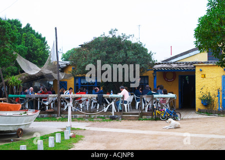 L'extérieur coin terrasse au restaurant, avec des gens assis en train de déjeuner de manger à l'ombre sous un arbre. au restaurant La Estacada sur le bord de Montevideo, Uruguay, Amérique du Sud Banque D'Images