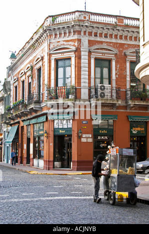 Dans le quartier de San Telmo autour de la Plaza Dorrego, un carré de vieilles maisons autour de la place, tous les magasins d'antiquités. logement maintenant, les gens qui marchent dans la rue. Calle Defensa Defence street et Humberto, un marchand de la rue selling popcorn à partir d'un chariot mobile Buenos Aires Argentine, Amérique du Sud Banque D'Images