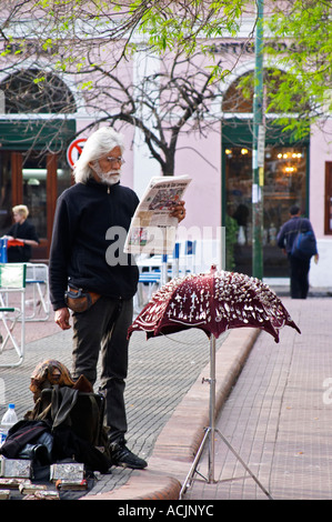 Dans le quartier de San Telmo autour de la Plaza Dorrego Square, sur la place, un homme en noir avec une barbe blanche et de longs cheveux blancs vente de petits bijoux et les axes d'un stand qui ressemble à un parapluie Buenos Aires Argentine, Amérique du Sud Banque D'Images