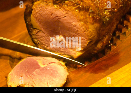 Le rôti de boeuf sculpté, rouges et juteuses à l'intérieur et beau brun carbonisé sur le grill à l'extérieur. Le couteau en découpant une tranche de la viande sur une planche à découper. Le Dolly Irigoyen - célèbre chef et présentatrice TV - restaurant privé, Buenos Aires Argentine, Amérique du Sud Espacio Dolli Banque D'Images