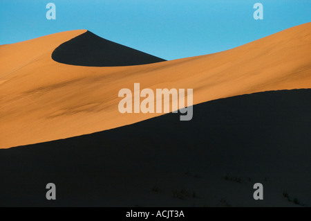 Abstraite de ciel bleu et les ombres sur une dune de sable à Kelso Dunes près du désert de Mojave en Californie. © Craig M. Eisenberg Banque D'Images