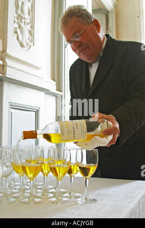 Apéritif servi dans le hall d'entrée, un verre jaune d or de Château de Cerons versé dans un verre d'un magnifique garçon butler Chateau de Cerons (Cérons) Sauternes Gironde Aquitaine France Banque D'Images