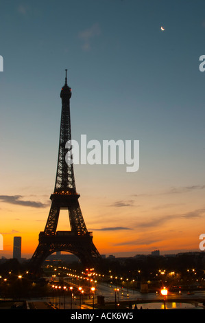 La Tour Eiffel à Paris au début de l'aube du matin avec le lever de soleil sur l'horizon, ciel bleu pâle quelques nuages blancs et le soleil jaune d'vu de la Place du Trocadéro square Paris France Banque D'Images