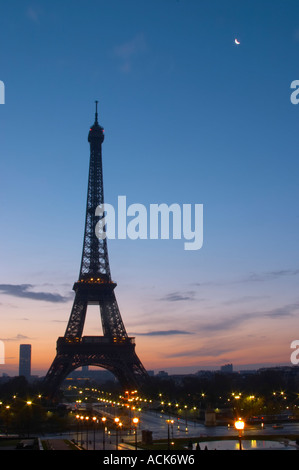 La Tour Eiffel à Paris au début de l'aube du matin avec le lever de soleil sur l'horizon, ciel bleu pâle quelques nuages blancs et le soleil jaune d'vu de la Place du Trocadéro square Paris France Banque D'Images