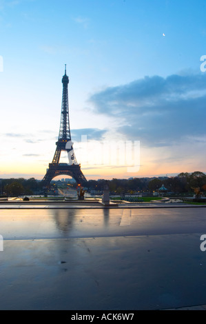 La Tour Eiffel à Paris au début de l'aube du matin avec le lever de soleil sur l'horizon, ciel bleu pâle quelques nuages blancs et le soleil jaune d'vu de la Place du Trocadéro square Paris France Banque D'Images