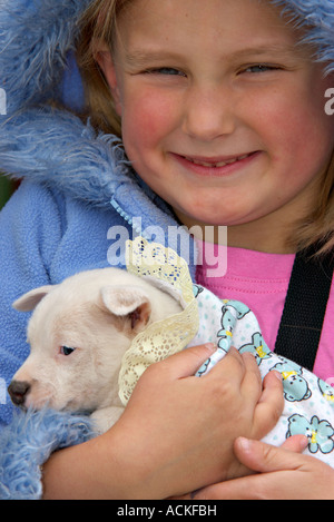 Une jeune fille est maintenant un tout petit chiot fox terrier Banque D'Images