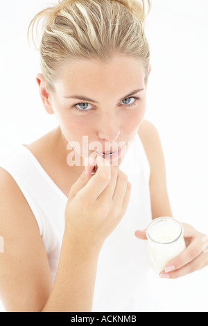 A young woman eating yoghurt Banque D'Images