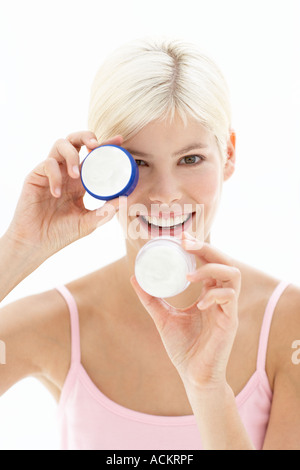 Une jeune femme jouant avec une bouteille de crème Banque D'Images