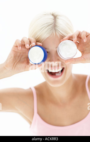 Une jeune femme jouant avec une bouteille de crème Banque D'Images