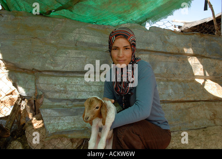 Un jeune villageois palestinien tient un agneau dans le hameau troglodyte de Khirbet Susya, dans les collines d'Hébron du Sud, en Cisjordanie Israël Banque D'Images