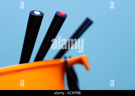 Caquelon avec les dents de couleur sur un fond bleu. Banque D'Images