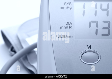 Détail d'une pression artérielle numérique et moniteur de fréquence cardiaque avec arm band. L'image monochrome teinté bleu Banque D'Images
