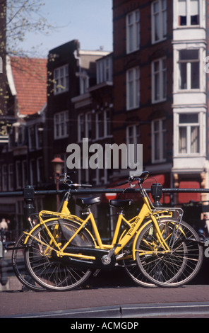 Deux bicyclettes jaune vif garé contre pont-canal, balustrades Spiegelgracht, Amsterdam, Pays-Bas Banque D'Images