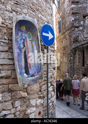 Groupe de touristes descendre rue étroite pièce passé d'art moderne qui s'interrompt sur le mur de pierre construit à l'époque romaine à côté d'un traf Banque D'Images