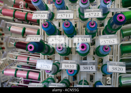 Des bobines de fil sur un rack dans un atelier de couture Banque D'Images