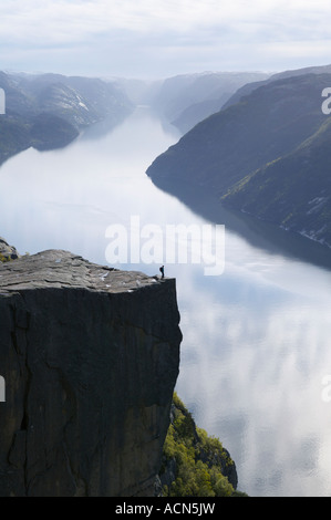 Walker debout sur Preikestolen, ou Pulpit Rock, au-dessus de Lysefjorden, Dale i Sunnfjord, Rogaland,. Banque D'Images