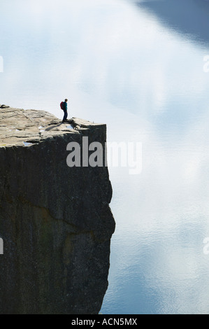 Walker debout sur Preikestolen, ou Pulpit Rock, au-dessus de Lysefjorden, Dale i Sunnfjord, Rogaland,. Banque D'Images