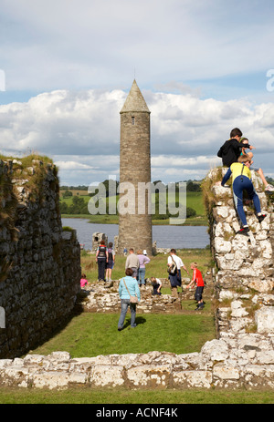 Les touristes et les enfants à l'escalade sur le Prieuré Augustin St Marys au-dessus de la tour ronde, sur l'île de Devenish Banque D'Images