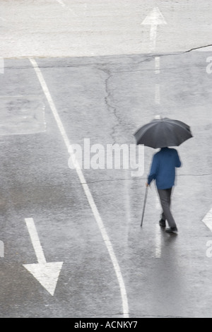 Vieil homme marchant sur une route Banque D'Images