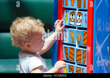 Un enfant joue avec un grand jouet éducatif. Banque D'Images