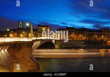 Un bateau-mouche qui passe sous le pont de la Tournelle à l'heure bleue, l'île Saint Louis, Paris, France Banque D'Images