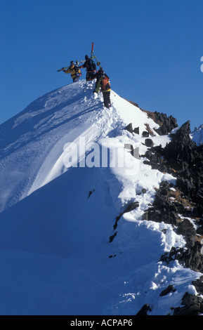 Quelques skieurs de skis sur les épaules pour trouver nouvelle neige Banque D'Images