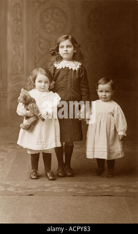 Portrait original en studio de jeunes filles victoriennes, sœurs, enfants victoriens agrippant un ours en peluche, début des années 1900, peut-être édouardien, Angleterre, Royaume-Uni Banque D'Images