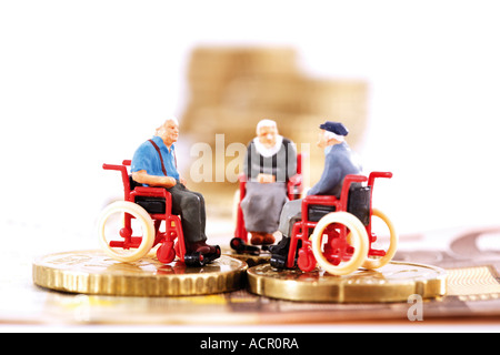 Univers miniatures en fauteuil roulant sur les pièces Banque D'Images