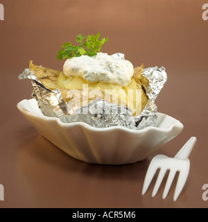 Pomme de terre au four avec du fromage dans du papier d'aluminium, close-up Banque D'Images