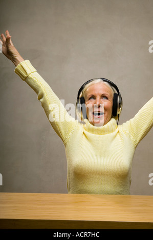 Senior woman wearing headphones, rire, close-up Banque D'Images