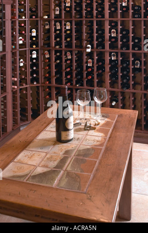 Bouteille de vin ouvert avec deux verres dans la cave avec des bouteilles de vin dans le stockage Banque D'Images