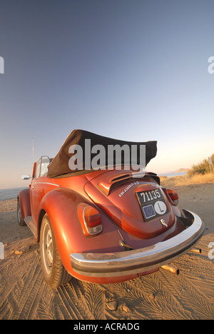 Un rouge-orange brillant Volkswagen Beetle convertible sur la plage. L'année 2007. Banque D'Images