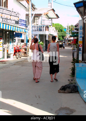 Deux jeunes femmes se promener dans Hat Rin village sur l'île de Ko Pha Ngan Thaïlande Banque D'Images