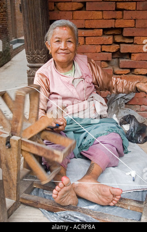 Une femme Newar laine tourne devant son domicile dans la vallée de Katmandou Népal Bhaktapur Banque D'Images