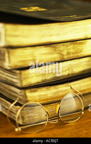 Lunettes cerclées de fil à côté pile de vieux livres Banque D'Images